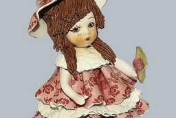 Статуэтка Кукла сидящая с темными волосами в розовом. ..